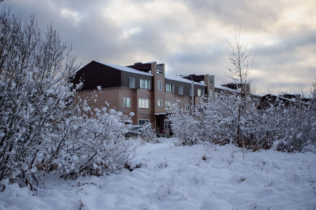 A snow covered field with a building in the background