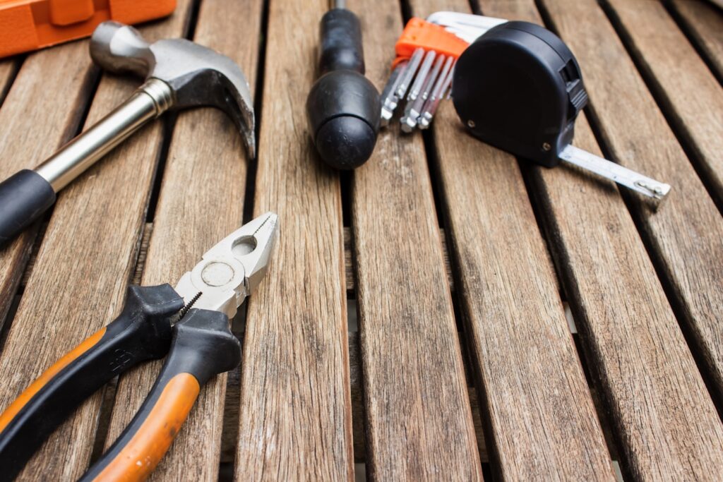 assorted-type carpentry tools on brown surface